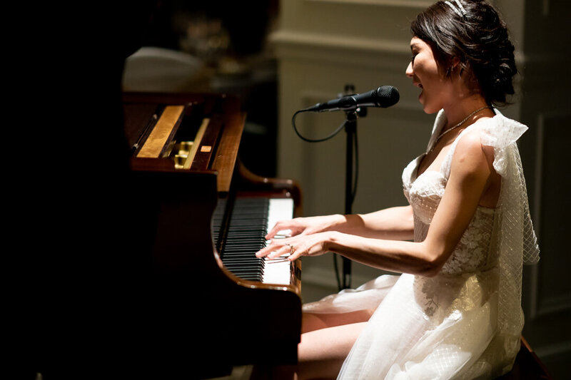Bride sings and plays piano at wedding reception