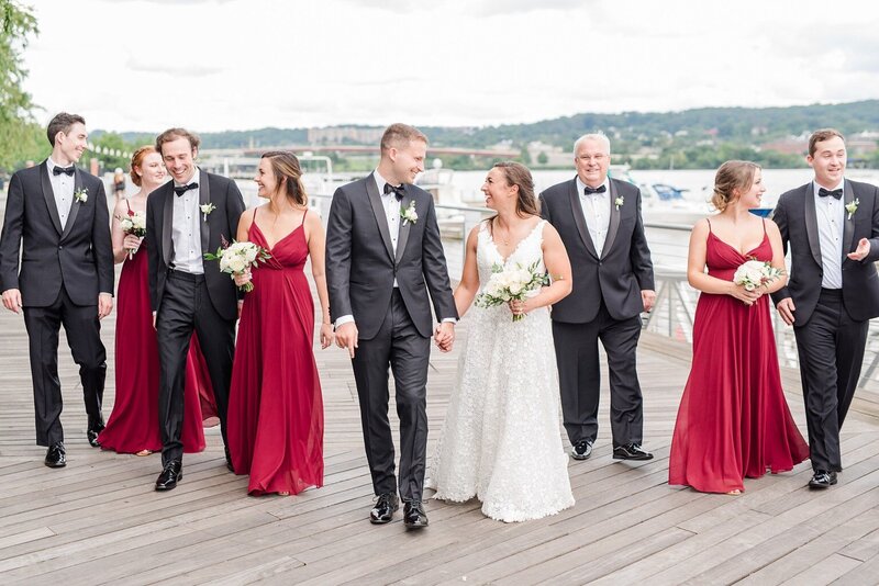 Bride with small bouquet and wedding party on waterfront pier in Washington DC