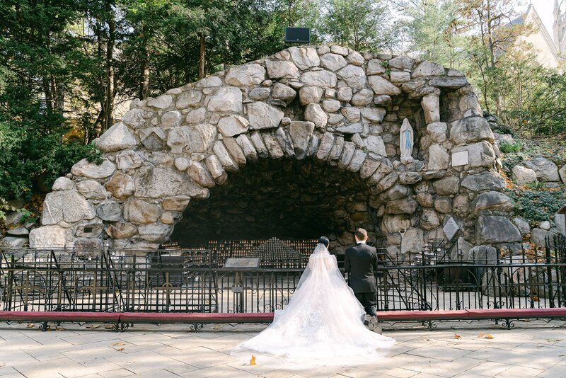 Bride and Groom pray at the Grotto on their wedding day in South Bend, Indiana