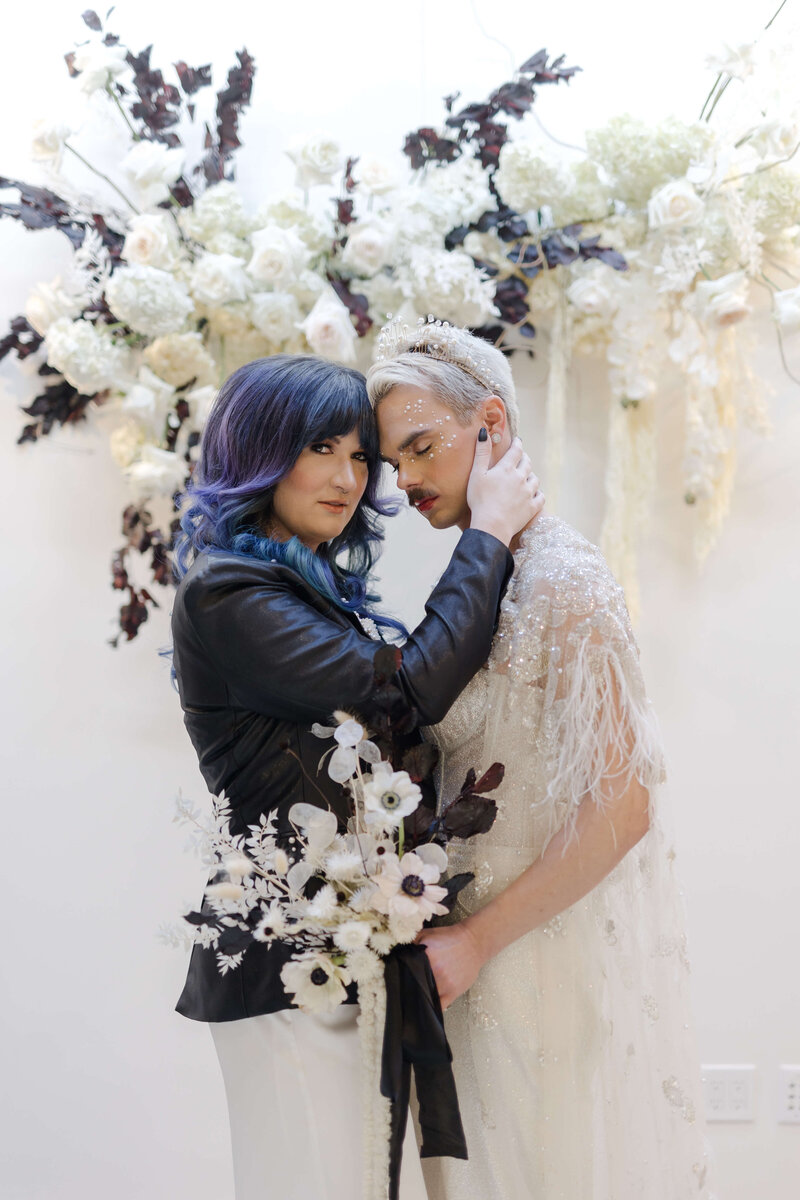 LGBTQ+ couple kissing and holding flower bouquet