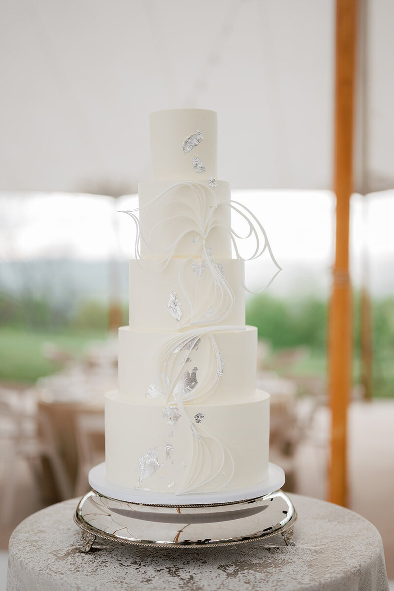 White architectural inspired wedding cake with a wafer paper filigree bow