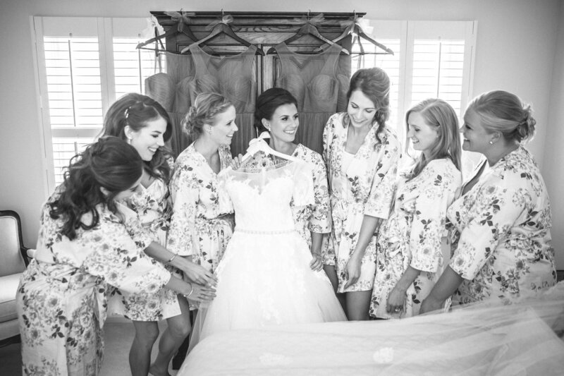 A bride is showing her wedding dress to her bridesmaids.