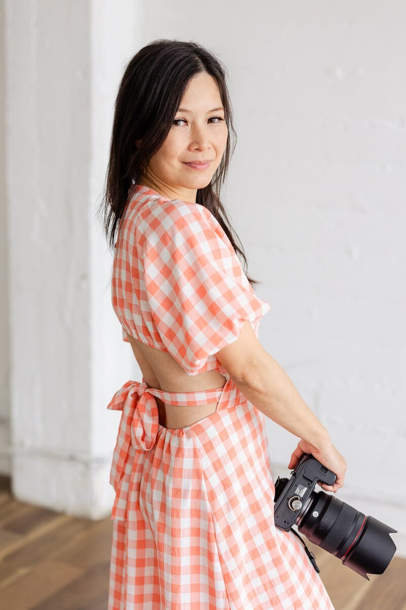 fashionable LA photographer holds her camera for a portrait
