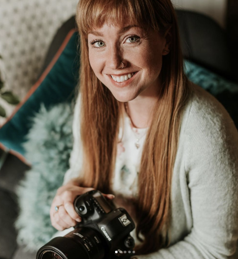 Client Aimee Joy captured by Client Hannah MacGregor woman with red hair and camera smiling