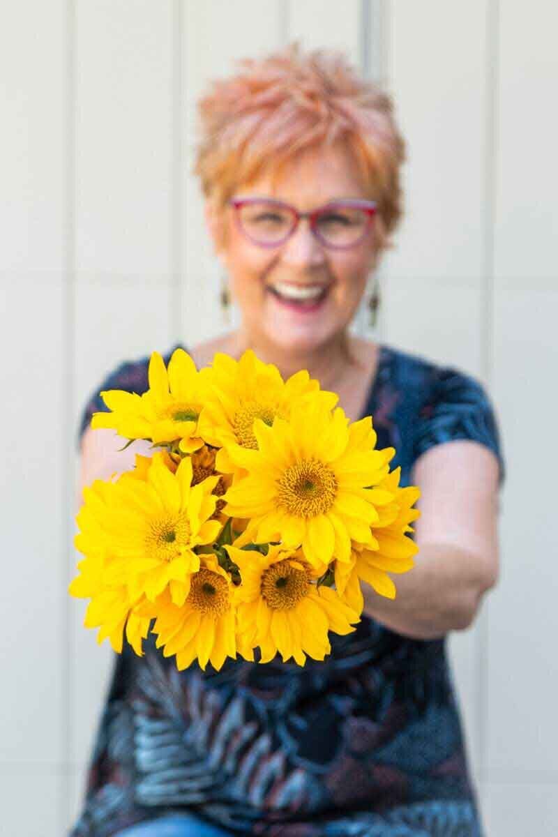 Jane Shine, blogger for Positively Jane, holding a bouquet of sunflowers