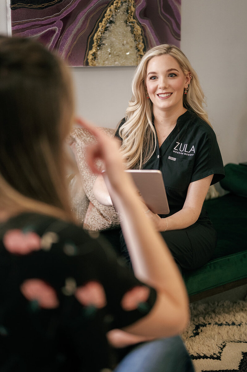 Zula Modern Medspa practitioner talking to patient while reviewing her ipad