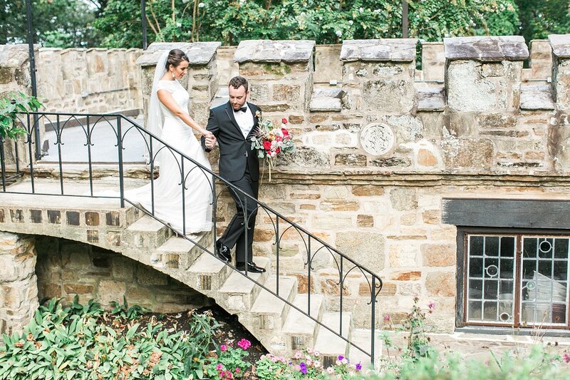 Bride and groom walk down stone castle steps