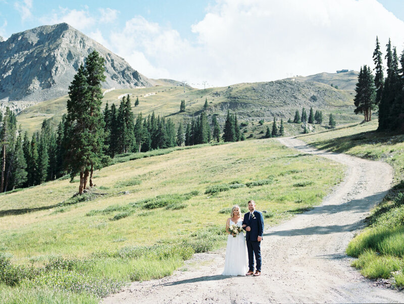 bride groom stand on mountain gravel road