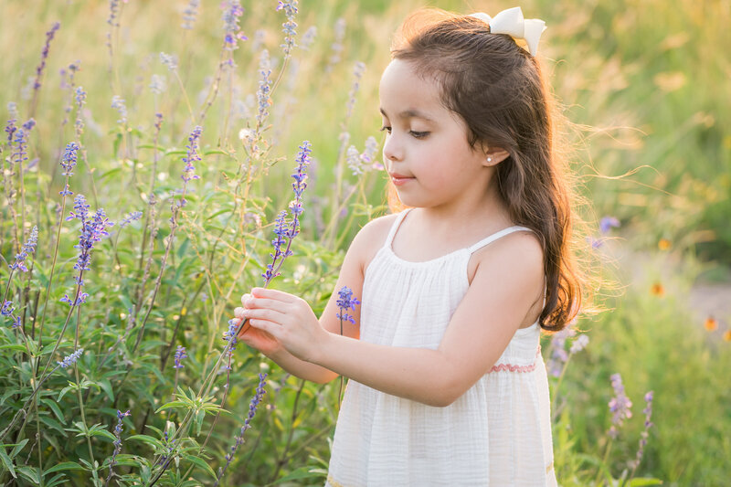 Girl with dress on looking at wildflowers, Austin Family Photographer