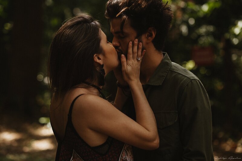 A romantic moment between a wedding photographer and her husband as they share a kiss, celebrating their love in the place where their story began—Hawaii.