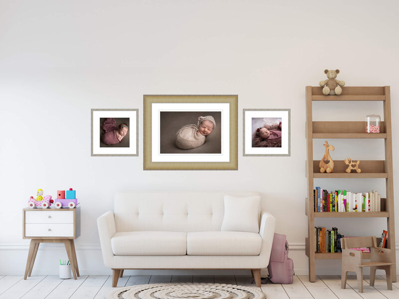 three framed portraits of a newborn hanging on a wall in a child's playroom