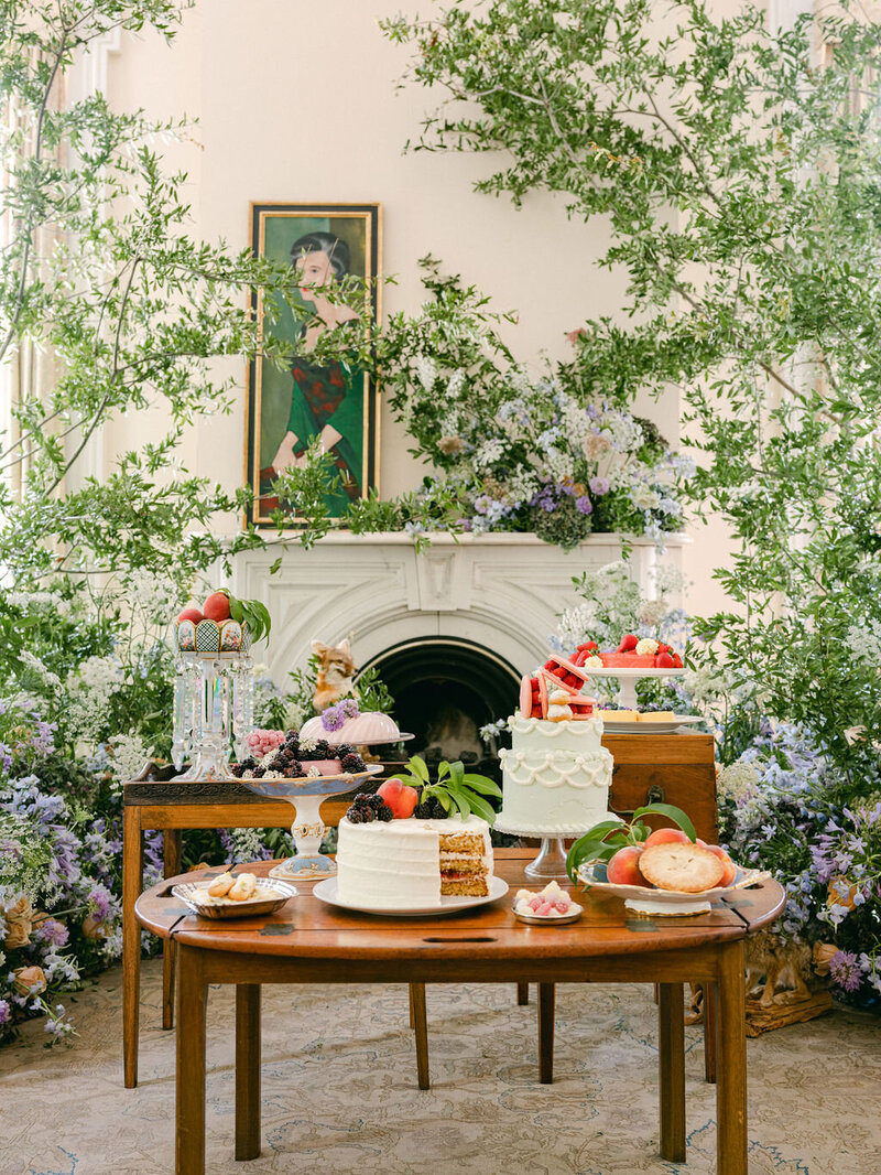 dessert table display with luxury florals and greenery