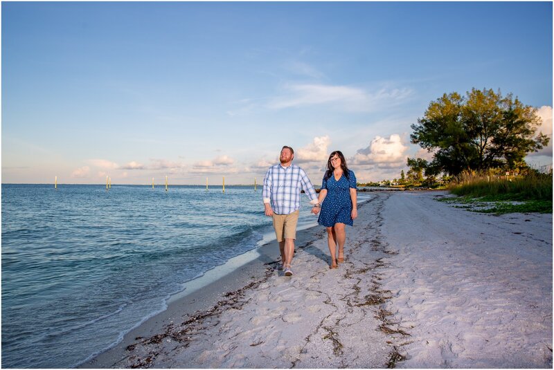 An engaged couple walking down the bayside of Anna Maria Island