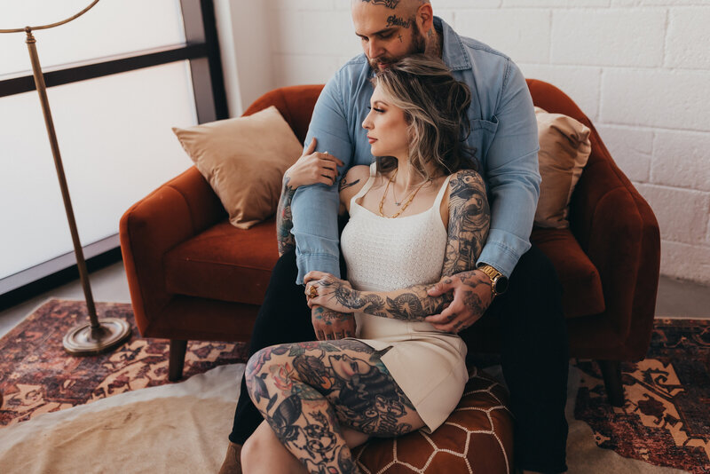 engaged couple snuggling in their living room for photos