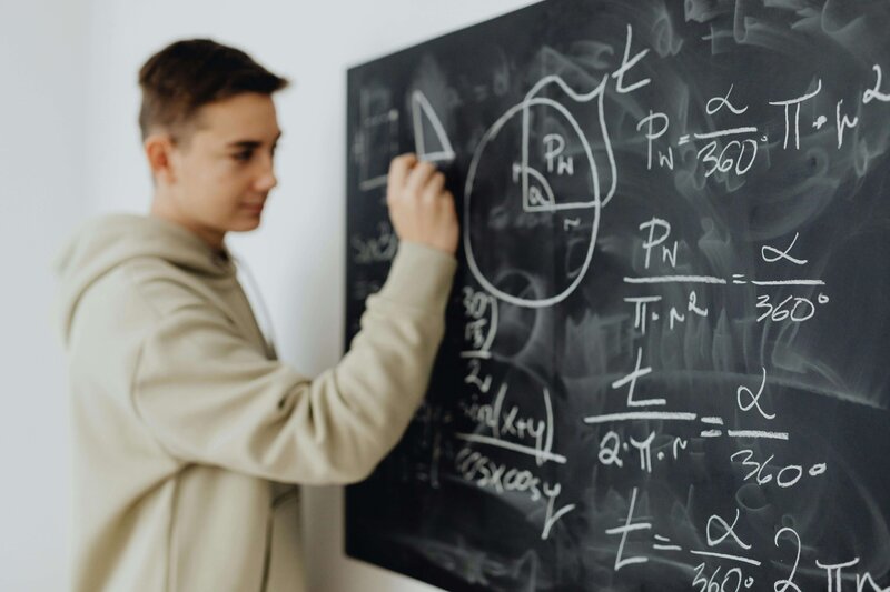 a student working at the chalkboard completing math