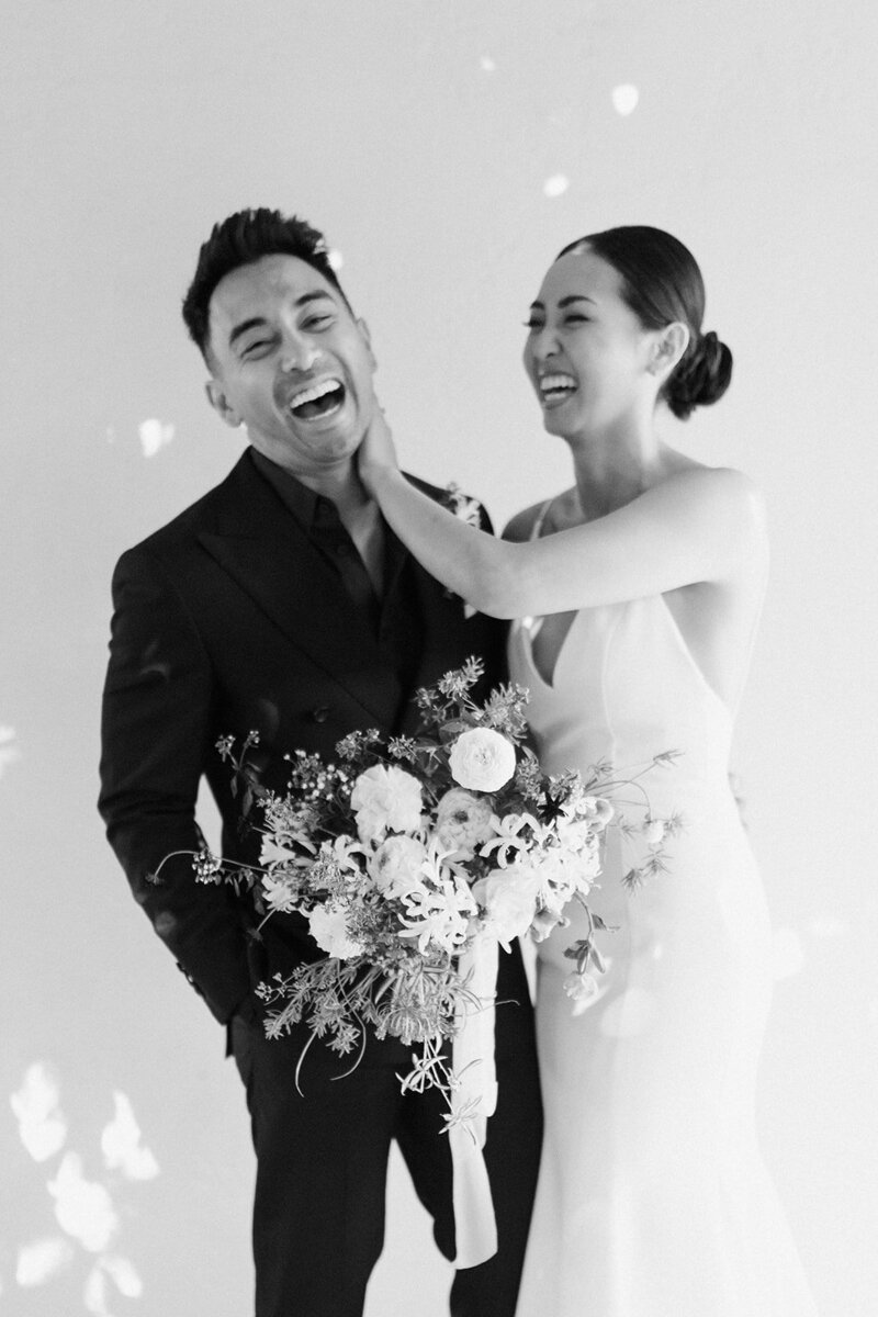 Bride with natural makeup laughing with groom