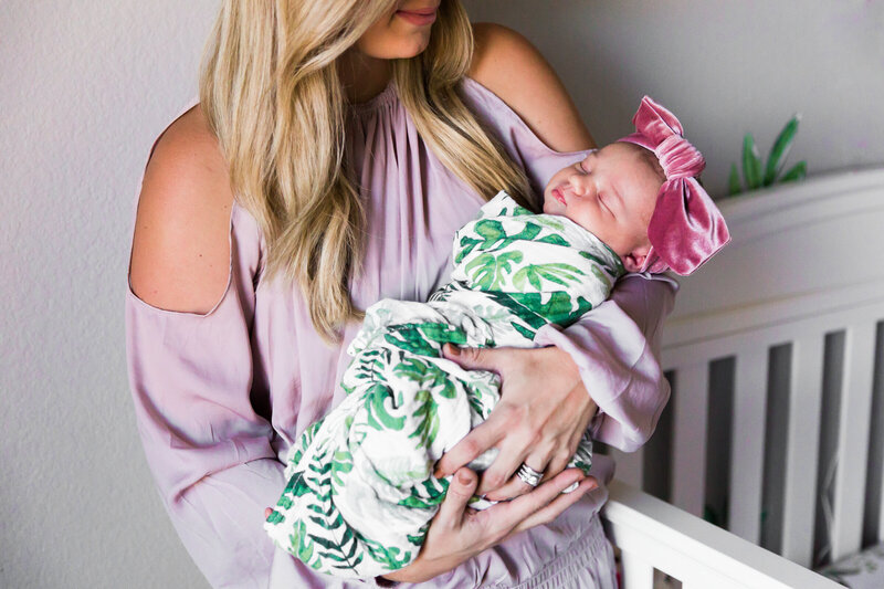 mom holding newborn baby girl in lifestyle newborn photos