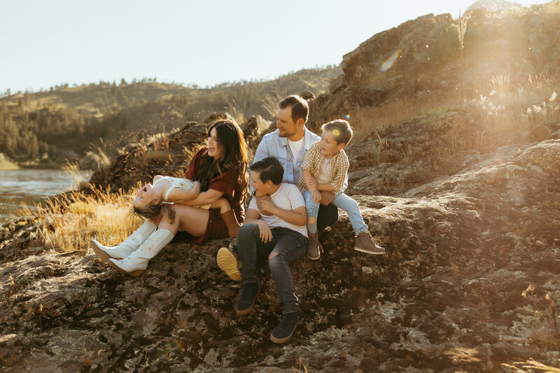 family sitting on rock landscape having fun