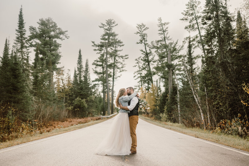 Bride and groom elopement couple kissing on a trail in Northern Minnesota