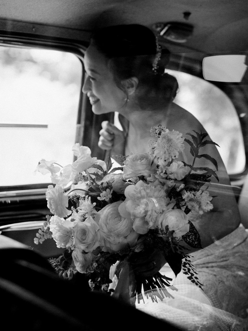 bride in taxi before wedding ceremony holding bouquet