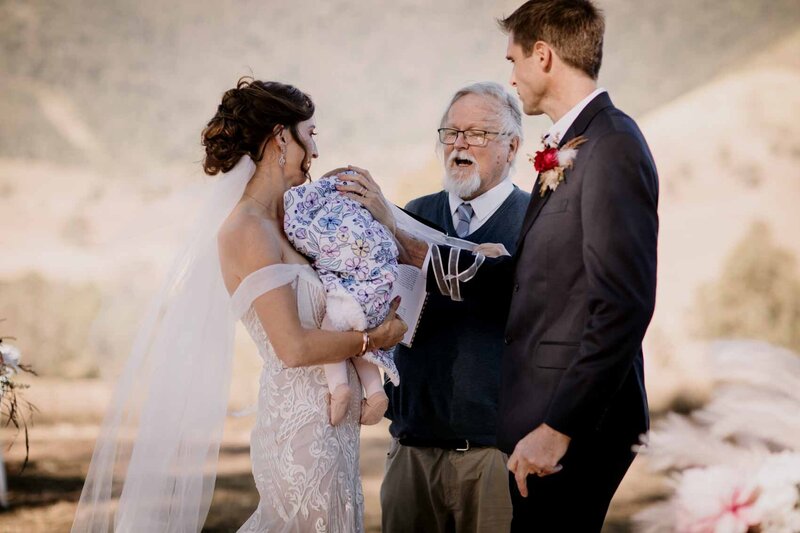 Bride and Groom held their new born baby at the altar on their wedding day