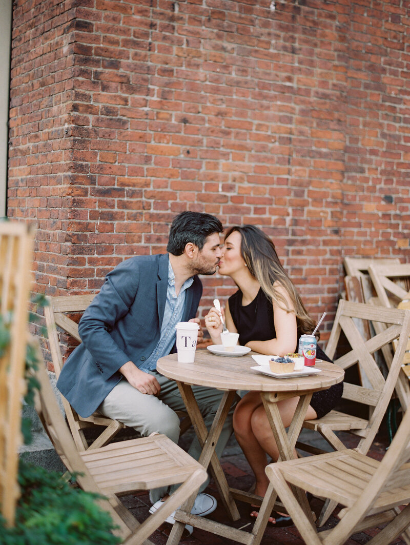 Couple kisses will eating dessert at Boston engagement session