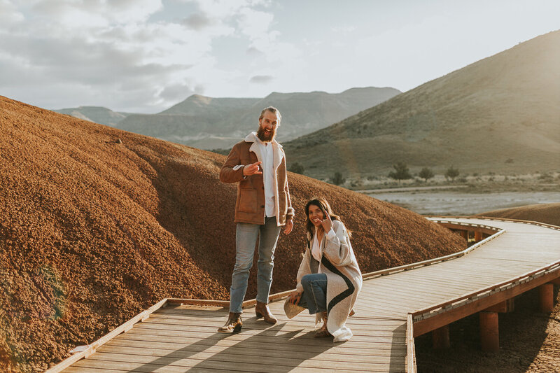 Boho couple poses at Painted Cove in Painted Hills Oregon during sunrise