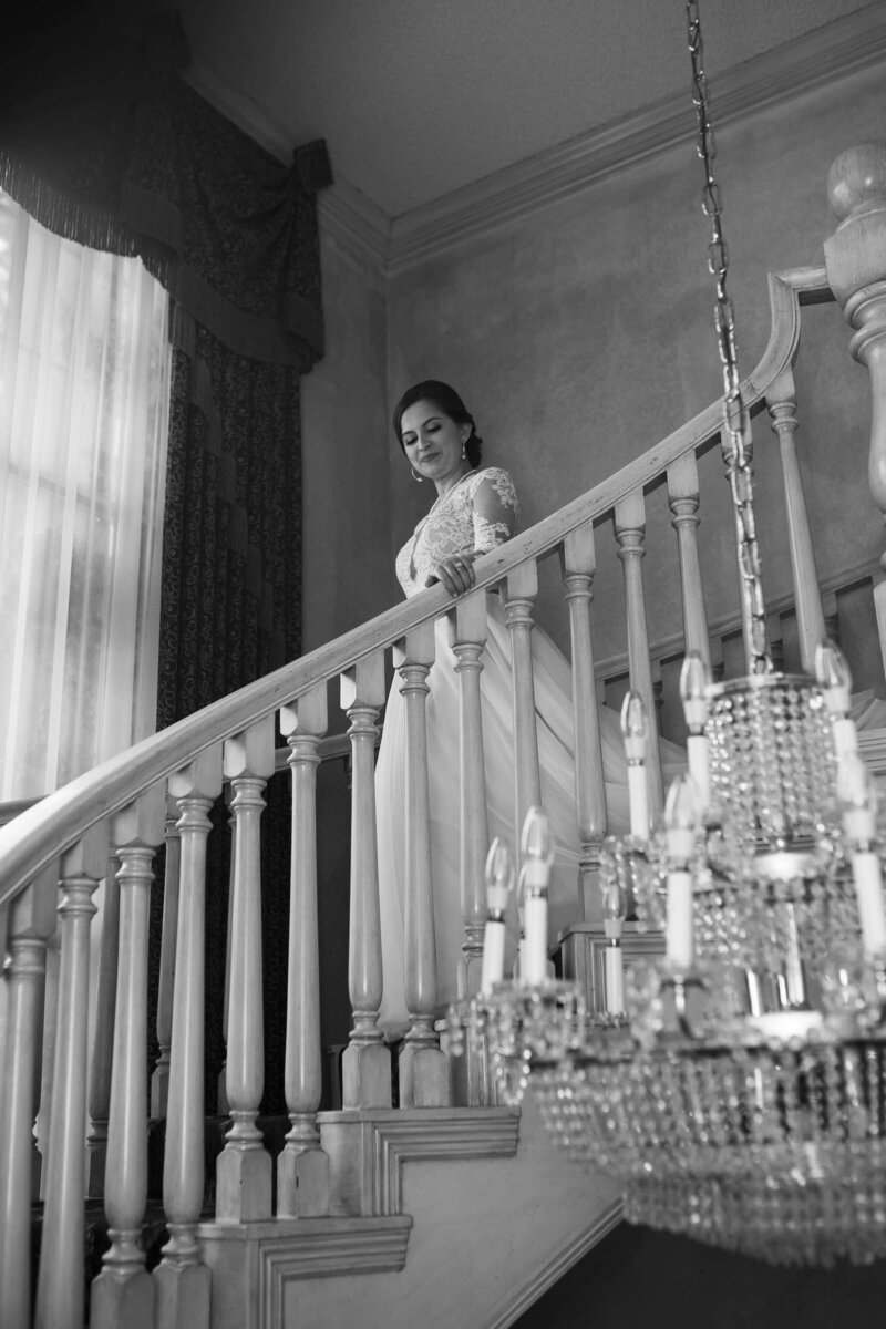 bride walks dow the stairs on her wedding day at Ashelynn Manor in Houston by Swish and Click Photography