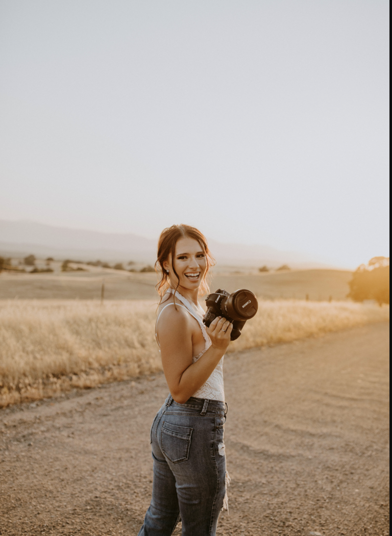 northern california wedding photographer poses with her camera at golden hour