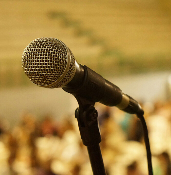 Photo of a microphone shown against a yellow background