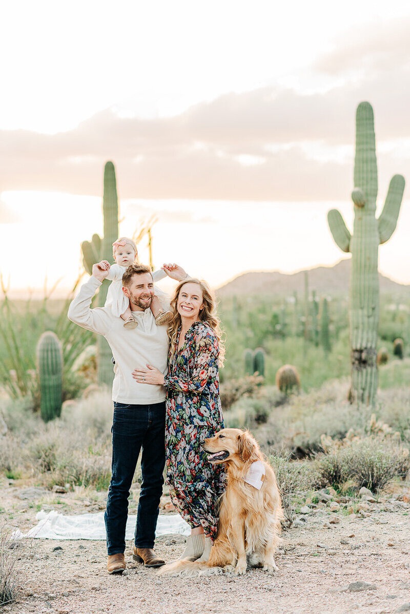 Phoenix family in candid photo with dog in outdoor Phoenix desert scenery.