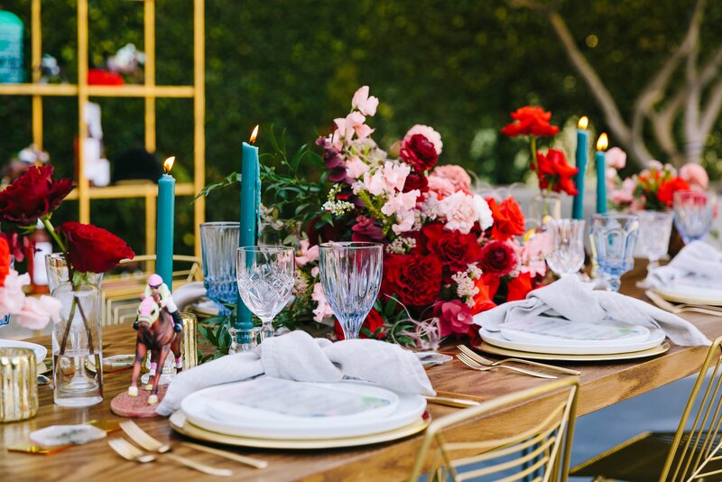 elegant table setting featuring roses and teal stick candles