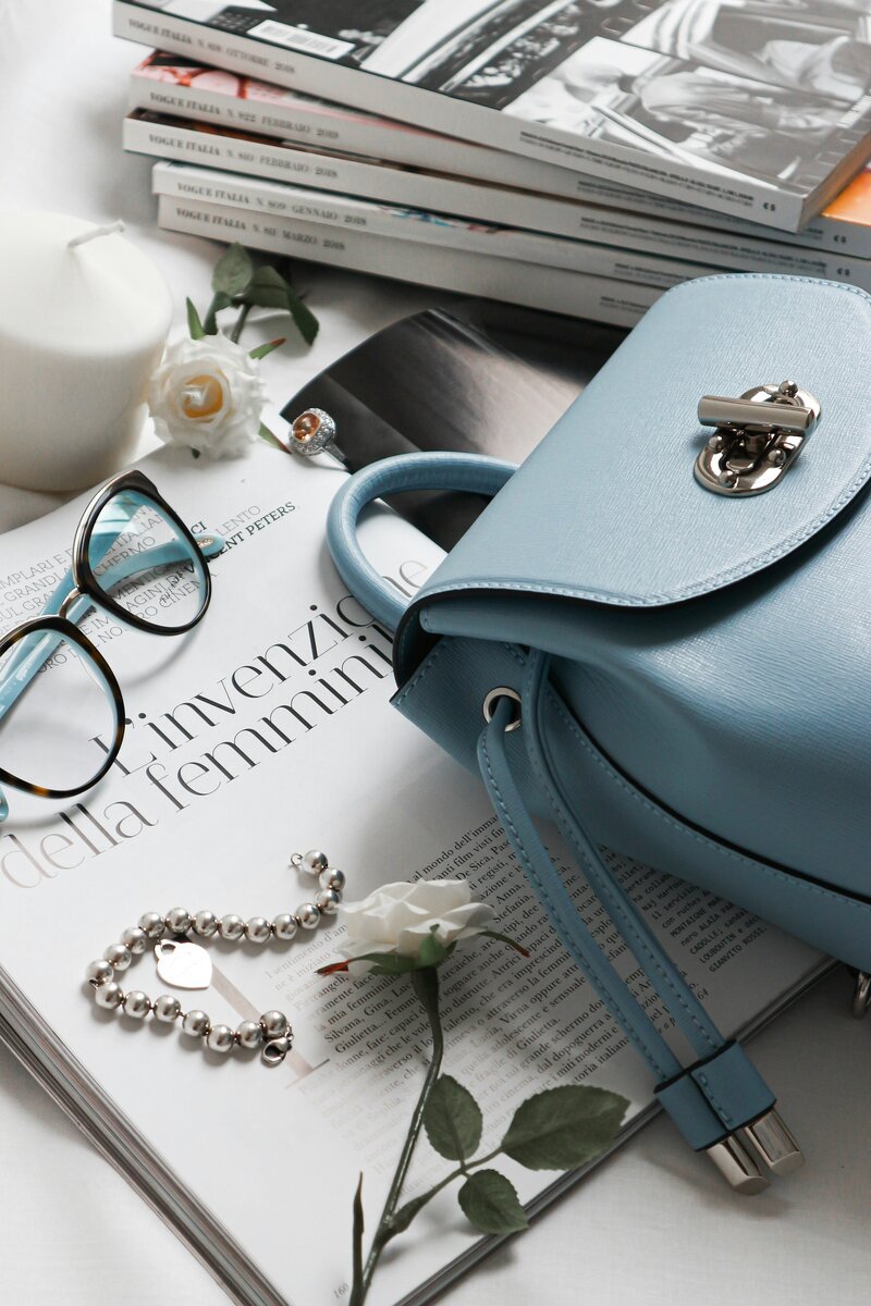 Interior design consultation essentials – lifestyle flatlay with handbag, glasses, and design books.