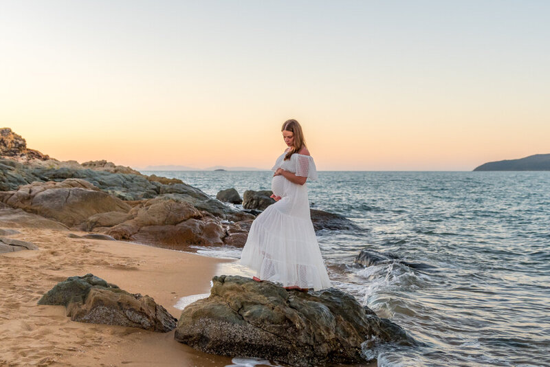 pregnant woman in white maternity dress on the beach  at sunset  townsville maternity photography by Jamie Simmons - Simmons Memorable Moments