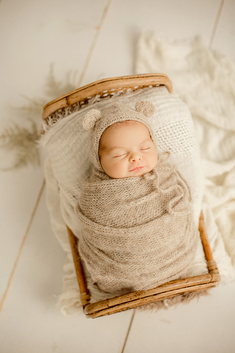 Studio photoshoot: A newborn wrapped in a cozy blanket, capturing adorable moments in a bright and airy setting.