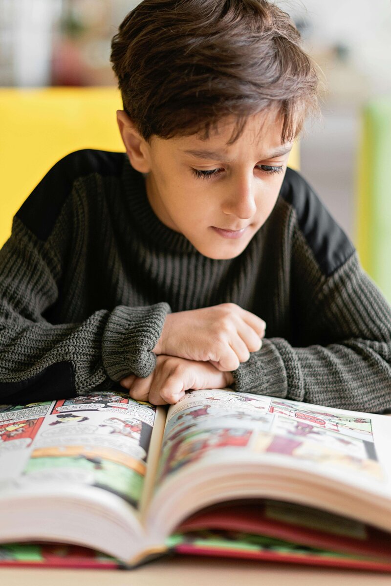 a male student reading a book in school