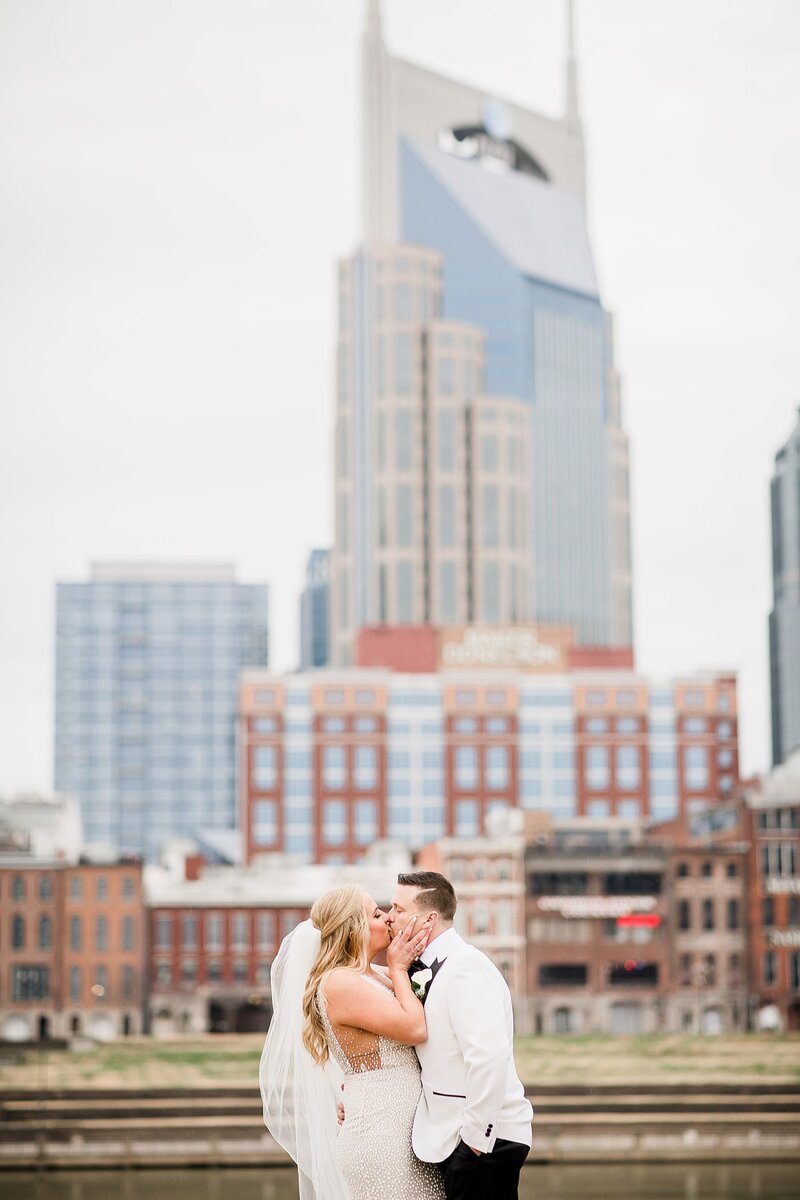 couple kissing in front of nashville skyline by Knoxville Wedding Photographer, Amanda May Photos