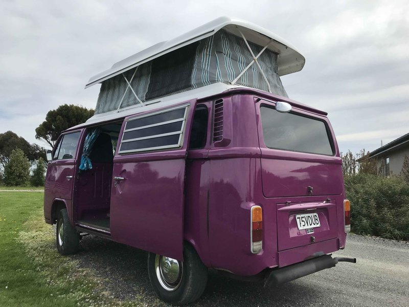 Outside view of left side with sliding door and pop top extended of Pippi, purple retro kombi van from NZ Kombi Hire