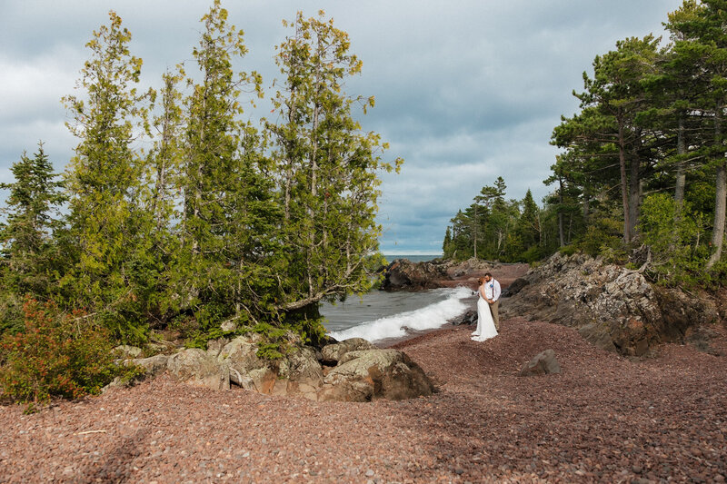 bride and groom laying on the grass faces towards one another