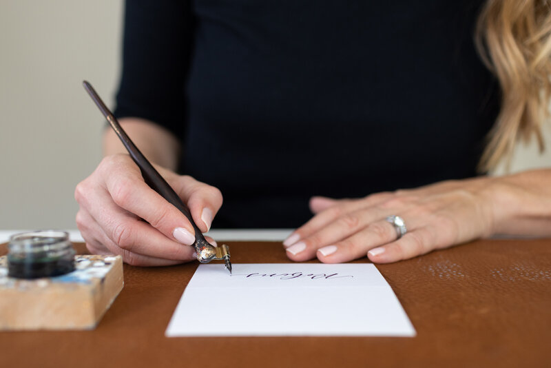 Close up of Connecticut calligrapher doing place card calligraphy at desk