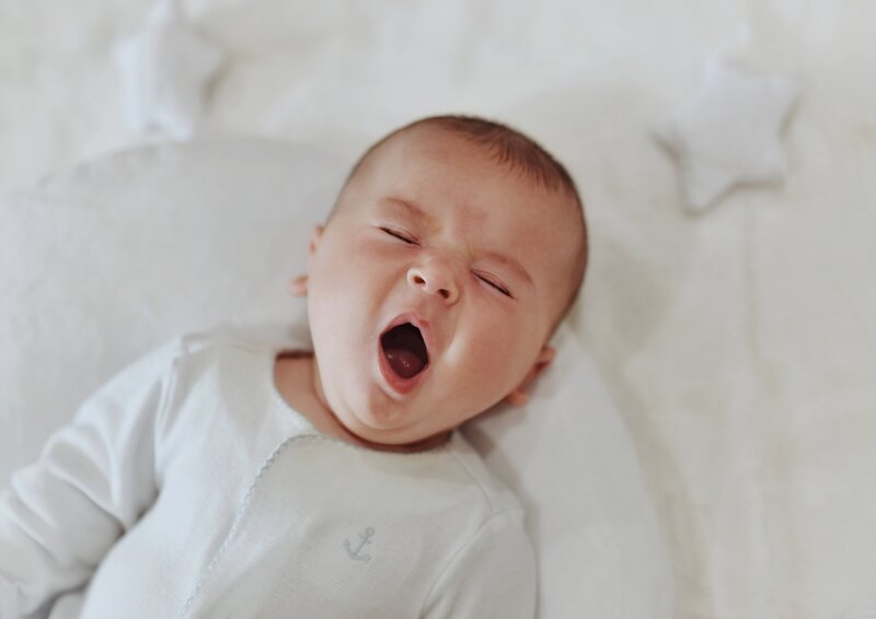 Baby lying down yawning