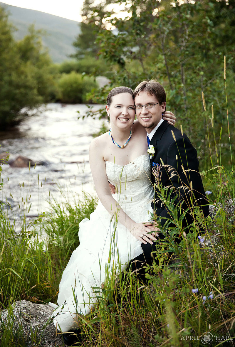 Cute wedding photo next to St. Vrain river at Wild Basin Lodge in Allenspark Colorado