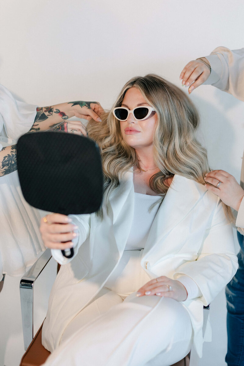 A stylist creating voluminous curls during a signature blowout service at SoCo Dry Bar