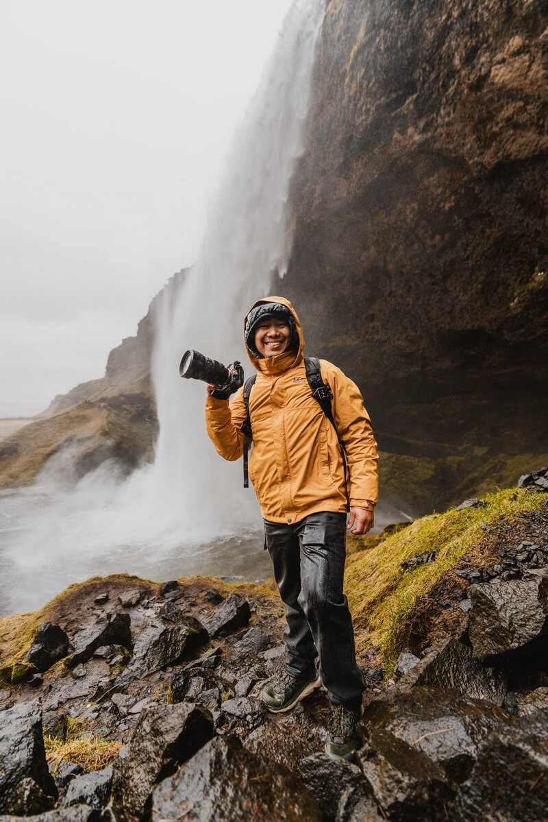 A fun portrait of John Bognot, the best Elopement and Wedding Photographer, at a waterfall in Iceland.