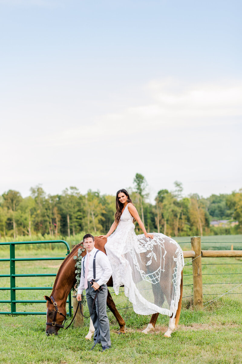 Bride on Horse with her husband standing beside her at Loveland Horse Farm