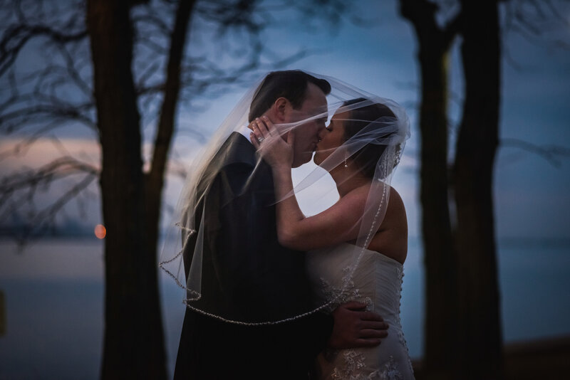Bride and groom kiss at sunset