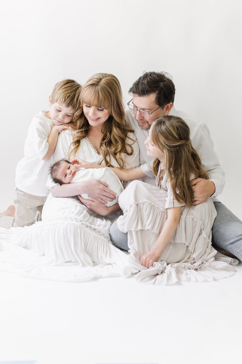 Newborn studio photo shoot with family of five.