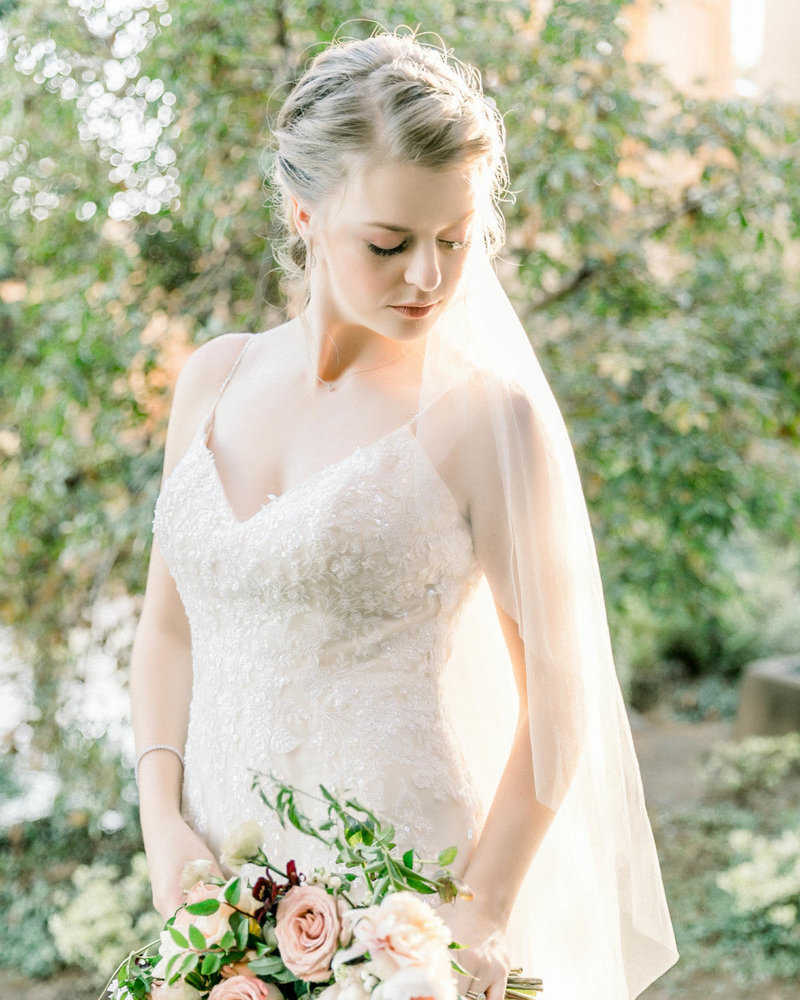 Portrait of Bride holding bouquet looking down to her left