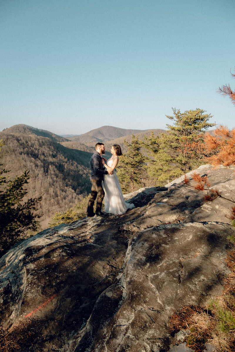 Couple standing on the edge of a mountain cliff