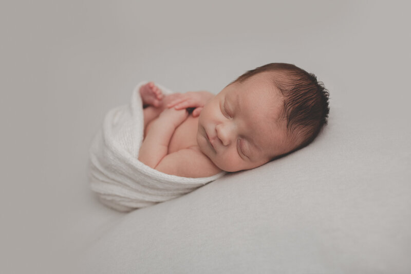 sleeping newborn with white wrap